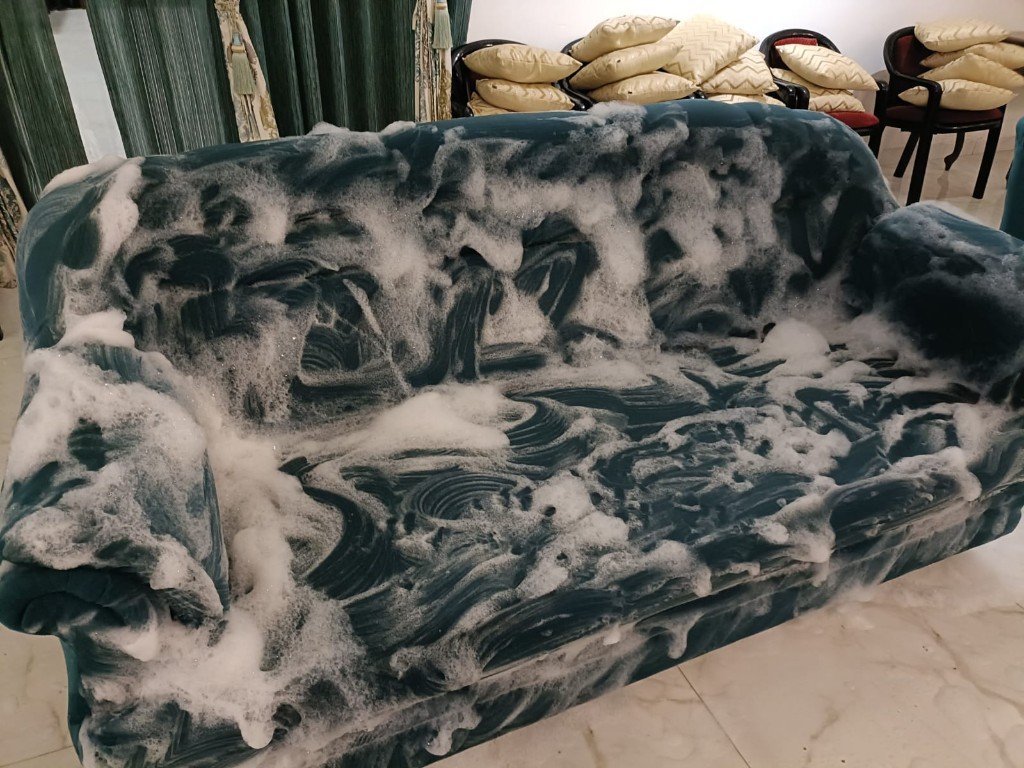 Teal fabric sofa covered in cleaning foam