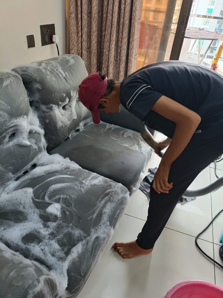 Perfect Cleaner technician deep-cleaning a sofa with professional foam in Vadodara